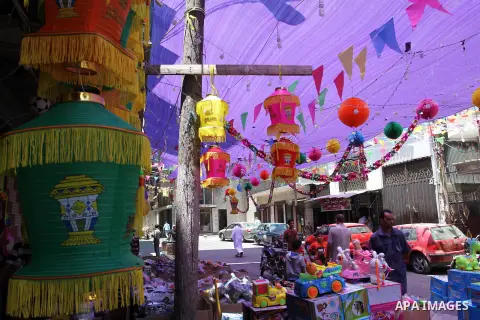 Palestinians walk at a market decorated by traditional Ramadan lanterns known as "Fanous" at a market, ahead of the holy fasting month of Ramadan in Khan Younis in the southern Gaza Strip, June 14, 2015. Photo by Abed Ra...