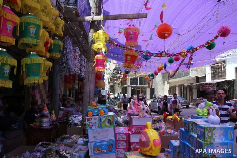 Palestinians walk at a market decorated by traditional Ramadan lanterns known as "Fanous" at a market, ahead of the holy fasting month of Ramadan in Khan Younis in the southern Gaza Strip, June 14, 2015. Photo by Abed Ra...