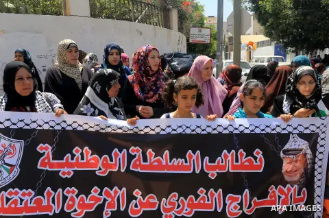 Palestinians who support PLC member of Fatah Mohammed Dahlan, hold banners during a protest demanding Palestinian Authority to release their relatives detained in its jails in Gaza on June 16, 2015. Photo by Mohammed Asa...