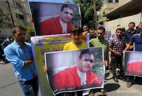 Palestinians who support PLC member of Fatah Mohammed Dahlan, hold banners during a protest demanding Palestinian Authority to release their relatives detained in its jails in Gaza on June 16, 2015. Photo by Mohammed Asa...