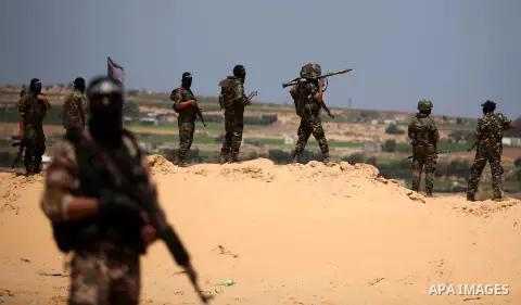 Palestinian militants of Al-Nasser Brigades, the armed wing of the Popular Resistance Committees, hold up their weapons during a military march, in Beit Hanoun in the northern Gaza Strip, June 16, 2015. Photo by Ashraf A...