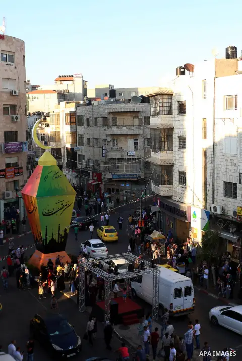 Palestinians gather around a huge lantern known as ''Fanous'' in a celebrating ahead of the holy fasting month of Ramadan in the West Bank city of Ramallah, June 16, 2015. Photo by Shadi Hatem