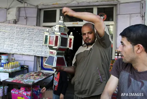 A Palestinian vendor holds a traditional lantern known in Arabic as "Fanous" in his market in Rafah in the southern Gaza strip as the faithful prepare for the start of the Muslim holy fasting month of Ramadan on June 17,...