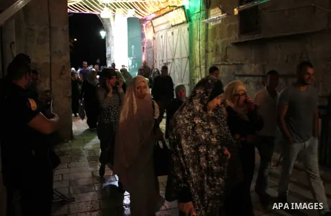 Palestinian Muslim worshipers walk outside the al-Al-Aqsa mosque following the first 'taraweeh', nightly prayer of the month of Ramadan, in Jerusalem's old city on June 17, 2015. Millions of Muslims around the world will...