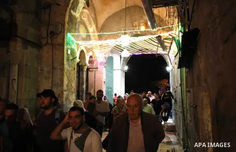 Palestinian Muslim worshipers walk outside the al-Al-Aqsa mosque following the first 'taraweeh', nightly prayer of the month of Ramadan, in Jerusalem's old city on June 17, 2015. Millions of Muslims around the world will...