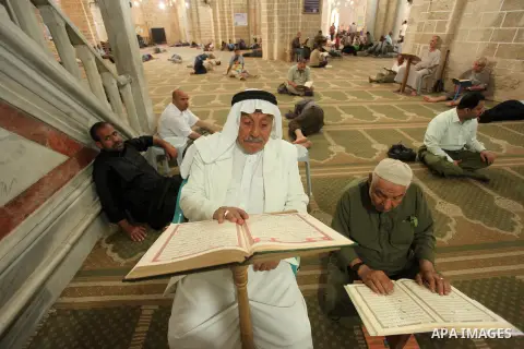 Palestinians rest as others pray and read the Koran in a mosque during the holy month of Ramadan in Gaza city on 18 June 2015. Muslims around the world are observing the holy fasting month of Ramadan in which they refrai...