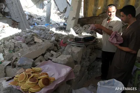 A Palestinian vendor prepares traditional pancakes known as ''Qatayef'' at his shop which was destroyed during the 50-day Israeli war in the summer of 2014, on the first day of the holy month of Ramadan, in Rafah in the...