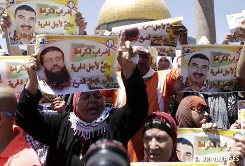 Palestinian Muslim worshipers shout slogans during a protest in support of the Palestinian Khader Adnan, a senior member of the Islamic Jihad who was jailed in Israel without a trial, following the first Friday prayer of...