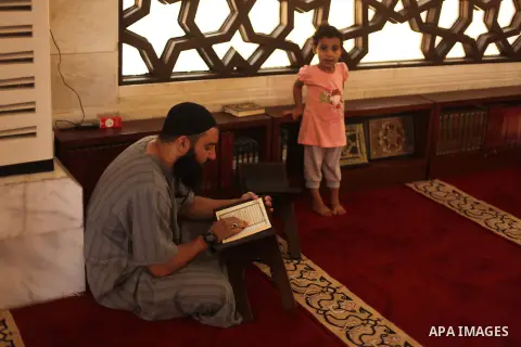 A Palestinian man reads the Koran in a mosque during the holy month of Ramadan in Gaza city on 20 June 2015. Muslims around the world are observing the holy fasting month of Ramadan in which they refrain from eating, dri...