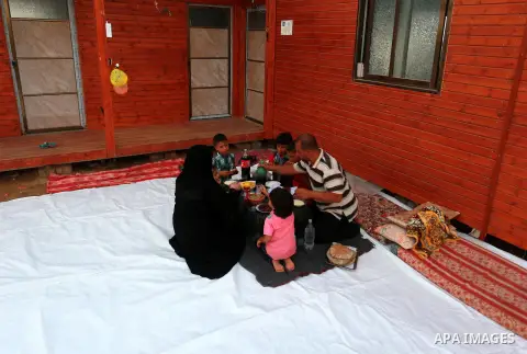 Members of a Palestinian family break their fast on the remains of their house, which was destroyed during the 50-day Israeli war in the summer of 2014, on the holy month of Ramadan, in KhanYounis in the southern Gaza St...