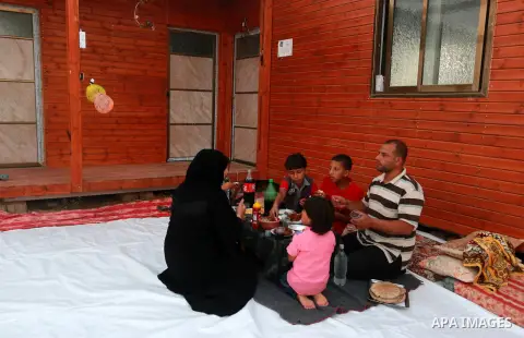 Members of a Palestinian family break their fast on the remains of their house, which was destroyed during the 50-day Israeli war in the summer of 2014, on the holy month of Ramadan, in KhanYounis in the southern Gaza St...