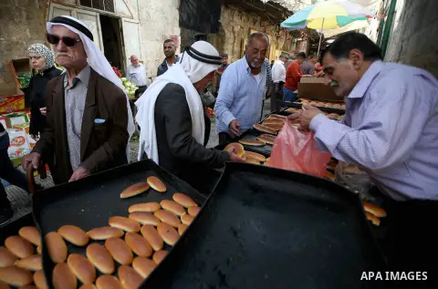 A Palestinian vendor sells breads in a street market on the holy month of Ramadan, in the West Bank city of Nablus on June 20, 2015. During Ramadan, Muslim believers abstain from eating, drinking, smoking and having sex...