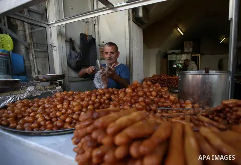 A Palestinian vendor sells breads in a street market on the holy month of Ramadan, in the West Bank city of Nablus on June 20, 2015. During Ramadan, Muslim believers abstain from eating, drinking, smoking and having sex...