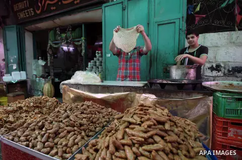 A Palestinian vendor sells breads in a street market on the holy month of Ramadan, in the West Bank city of Nablus on June 20, 2015. During Ramadan, Muslim believers abstain from eating, drinking, smoking and having sex...