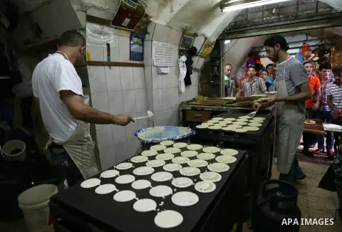 A Palestinian vendor prepares traditional pancakes known as ''Qatayef'' at his shop on the holy month of Ramadan, in the West Bank city of Nablus on June 20, 2015. During Ramadan, Muslim believers abstain from eating, dr...