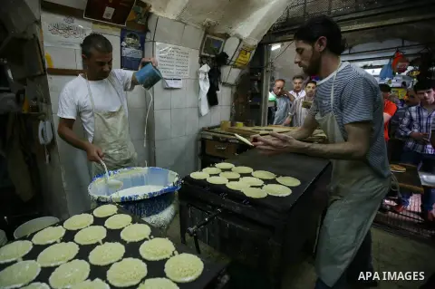 A Palestinian vendor prepares traditional pancakes known as ''Qatayef'' at his shop on the holy month of Ramadan, in the West Bank city of Nablus on June 20, 2015. During Ramadan, Muslim believers abstain from eating, dr...