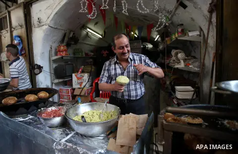 A Palestinian vendor sells Falafel in a street market on the holy month of Ramadan, in the West Bank city of Nablus on June 20, 2015. During Ramadan, Muslim believers abstain from eating, drinking, smoking and having sex...