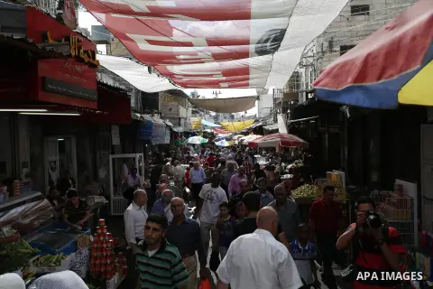Palestinians walk in a street market on the holy month of Ramadan, in the West Bank city of Nablus on June 20, 2015. During Ramadan, Muslim believers abstain from eating, drinking, smoking and having sex from dawn until...