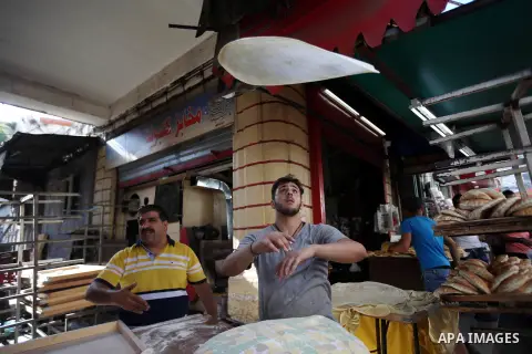 A Palestinian vendor sells breads in a street market on the holy month of Ramadan, in the West Bank city of Nablus on June 20, 2015. During Ramadan, Muslim believers abstain from eating, drinking, smoking and having sex...