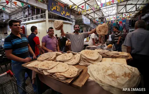 A Palestinian vendor sells breads in a street market on the holy month of Ramadan, in the West Bank city of Nablus on June 20, 2015. During Ramadan, Muslim believers abstain from eating, drinking, smoking and having sex...