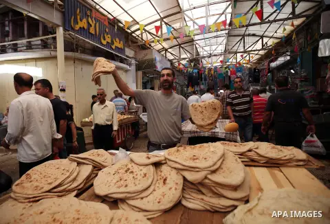 A Palestinian vendor sells breads in a street market on the holy month of Ramadan, in the West Bank city of Nablus on June 20, 2015. During Ramadan, Muslim believers abstain from eating, drinking, smoking and having sex...