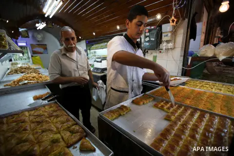 A Palestinian vendor sells sweets in a street market on the holy month of Ramadan, in the West Bank city of Nablus on June 20, 2015. During Ramadan, Muslim believers abstain from eating, drinking, smoking and having sex...