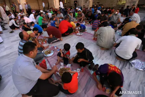 Palestinians break their fast in a feast organised by Turkish Cooperation and Coordination Agency "TİKA" during the holy fasting month of Ramadan, at al-Omary mosque in Gaza city on June 21, 2015. During Ramadan, Muslim...