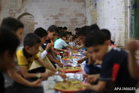 Palestinians break their fast in a feast organised by Turkish Cooperation and Coordination Agency "TİKA" during the holy fasting month of Ramadan, at al-Omary mosque in Gaza city on June 21, 2015. During Ramadan, Muslim...