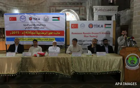 Palestinian volunteers prepare donated food for Iftar (the evening meal during the Islamic month of Ramadan), organised by Turkish Cooperation and Coordination Agency "TİKA" during the holy fasting month of Ramadan, at a...