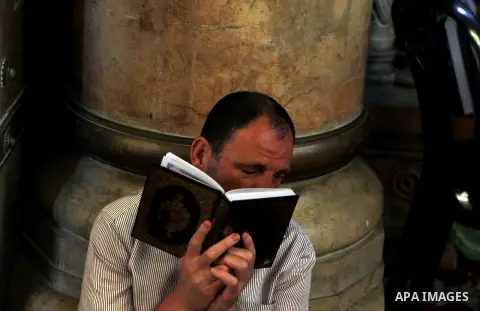 A Palestinian man reads the Koran at the Al-Aqsa Mosque compound during the Muslim holy month of Ramadan, in Jerusalem, on June 23, 2015. Most Muslims around the world have begun observing the holy fasting month of Ramad...