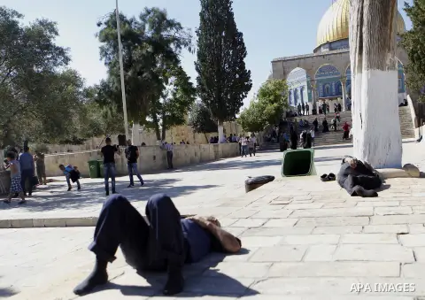 Palestinians rest as others pray and read the Koran outside the Dome of the Rock at the Al-Aqsa Mosque compound during the Muslim holy month of Ramadan, in Jerusalem, on June 23, 2015. Most Muslims around the world have...