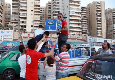 Egyptians carry water bottles as others wait to break their daytime fast, during the Muslim holy month of Ramadan, in Egypt s Mediterranean city of Alexandria, Friday, June 26, 2015. Alexandria is seeking to enter the Gu...