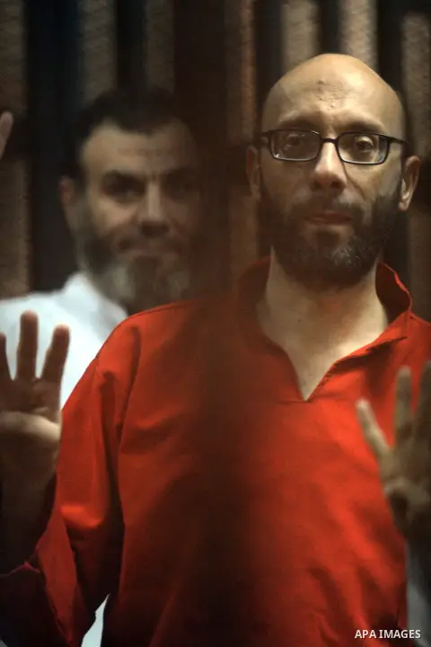 Egyptian Muslim Brotherhood defendants stand behind the bars during their trial, along with ousted Islamist president Mohamed Morsi (unseen), in Cairo on June 27, 2015. Photo by Amr Sayed