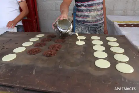 A Palestinian man prepares traditional pancakes known as ''Qatayef'' in a street market on the holy month of Ramadan, in Rafah in the southern Gaza Strip on June 27, 2015. During Ramadan, Muslim believers abstain from ea...