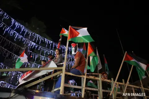 Palestinian activists sit on a model of a ship during a rally in solidarity with activists aboard a flotilla of boats who are soon to set sail for Gaza in a fresh bid to break Israel's blockade of the territory, in the W...
