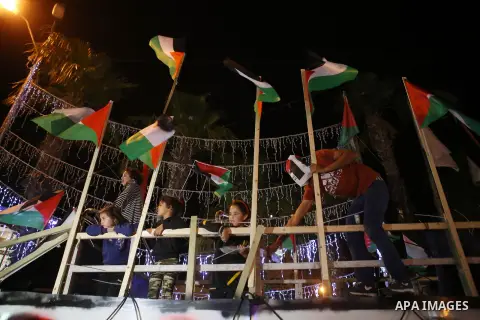 Palestinian activists sit on a model of a ship during a rally in solidarity with activists aboard a flotilla of boats who are soon to set sail for Gaza in a fresh bid to break Israel's blockade of the territory, in the W...