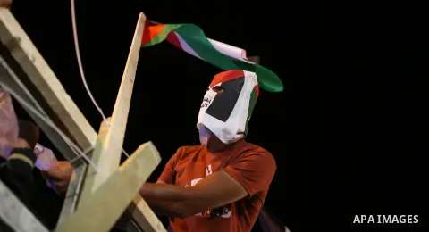 A Palestinian activist sist on a model of a ship during a rally in solidarity with activists aboard a flotilla of boats who are soon to set sail for Gaza in a fresh bid to break Israel's blockade of the territory, in the...
