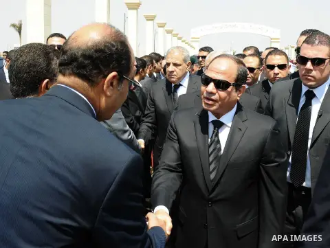 Egyptian president Abdel-Fattah el-Sissi, center, attends the funeral for Hisham Barakat, surrounded by his family members, the top judicial official in charge of overseeing the prosecution of thousands of Islamists, inc...