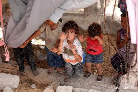 Palestinian childern play on the ruins of houses, that witnesses said were destroyed by Israeli shelling during a 50-day war last summer, in Khan Younis in the southern Gaza Strip July 2, 2015. Robert Turner has no quick...
