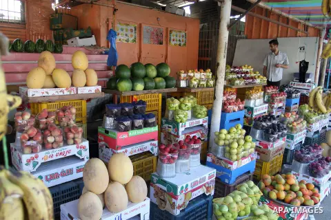 A Palestinian vendor sells fruits at his shop in Rafah in the southern Gaza Strip, on July 12, 2015. Photo by Abed Rahim Khatib