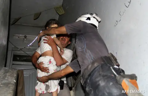 Syrian firefighters carry children following a reported bomb barrel attack by Syrian government forces at al-Salheen neighborhood in the northern Syrian city of Aleppo, July 12, 2015. Photo by Ameer al-Halbi