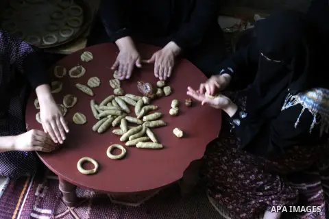 Palestinian women prepare date-filled mini cakes traditional for the Eid al-Fitr, a three-day holiday that marks the end of the fasting month of Ramadan, in Rafah in the southern Gaza Strip on July 14, 2015, as Muslims t...