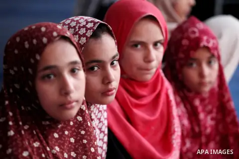Palestinian girls pose for a photograph during the Eid al-Fitr prayer, marking the end of the fasting month of Ramadan, in Gaza City's eastern suburb of Al-Shejaiya, on July 17, 2015. Photo by Ashraf Amra