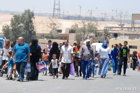 Egyptians walk in front of the Giza pyramids, on the third day of Eid al-Fitr holiday which marks the end of the Muslim holy month of Ramadan, in Cairo on July 19, 2015. Photo by Amr Sayed
