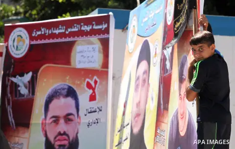 Palestinians hold placards during a protest in solidarity with Palestinian prisoners in Israeli jails, in front of high commissioner for human rights headquarters, in Gaza City on July 22, 2015. Photo by Ashraf Amra