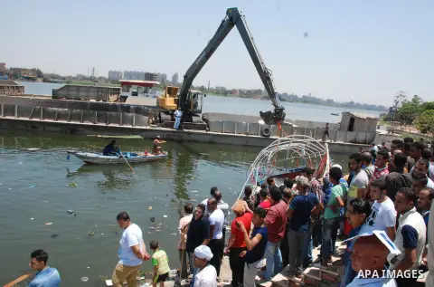 Egyptians gather at the site of a shipwreck on the Nile River in the Warraq district of Giza, southwest of Cairo, Egypt, on July 23, 2015. At least 19 people died Wednesday in a shipwreck on Nile River in Cairo, capital...
