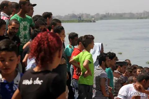 People, including relatives, react along during a search for the victims of a boat collision on the River Nile in the Warraq area of Giza, south of Cairo, Egypt, July 23, 2015. At least 15 people drowned when the small b...