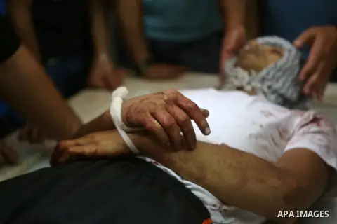 Palestinians place flowers on the body of Palestinian Mohammed Abu Latifa, 19, at a hospital morgue in the West Bank city of Ramallah July 27, 2015. Abu Latifa, wanted on suspicion of planning a militant attack, fell to...