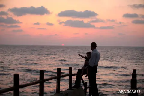 Palestiniansl stand along the beach of Gaza city during the sunset, on July 27, 2015. Independent Commission for Human Rights warned Saturday of the aggravated humanitarian situation in Gaza due to continued electricity...