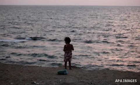 A Palestinian girl stands along the beach of Gaza city during the sunset, on July 27, 2015. Independent Commission for Human Rights warned Saturday of the aggravated humanitarian situation in Gaza due to continued electr...